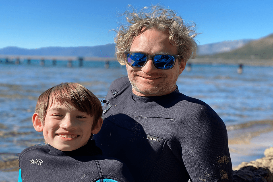特拉维斯·霍夫斯泰特(A&2005年，他和儿子穿着潜水服在海滩上玩耍.