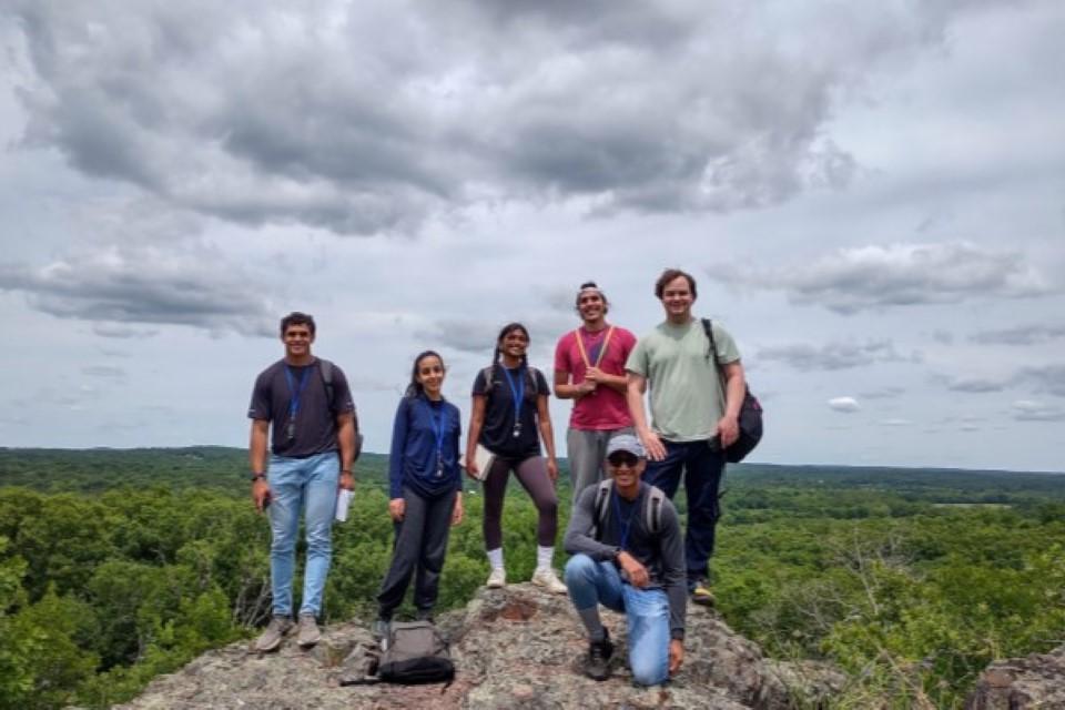 一群六名学生站在悬崖顶上，俯瞰着奥扎克森林. 