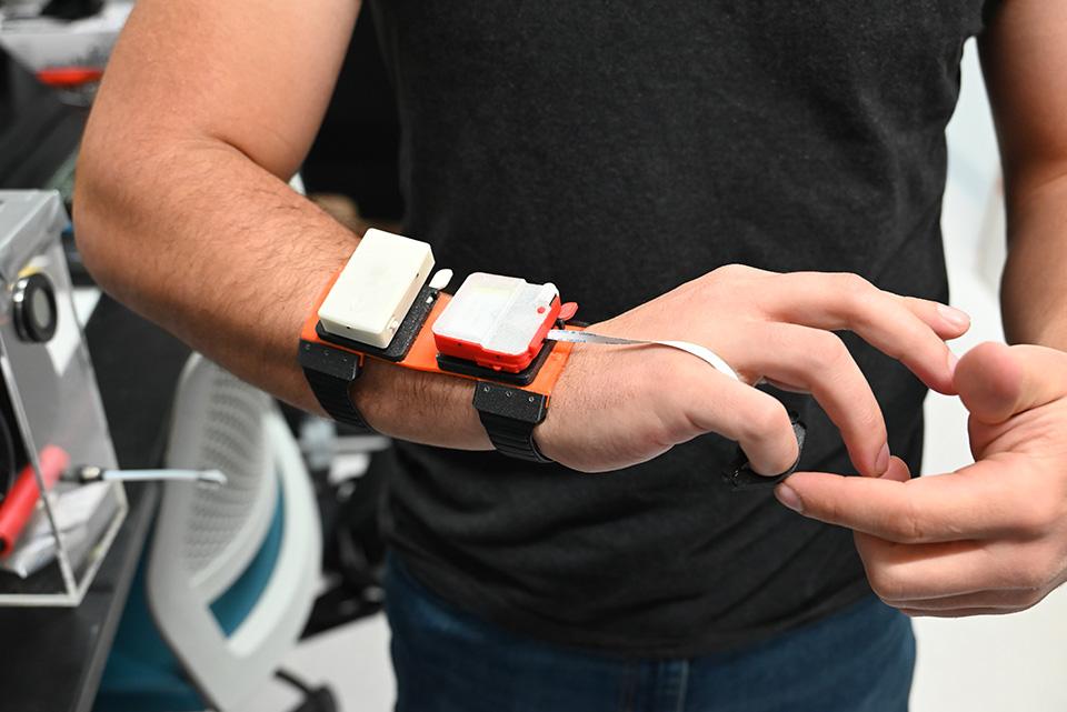 一名研究人员的手腕上戴着一个触觉装置的原型.