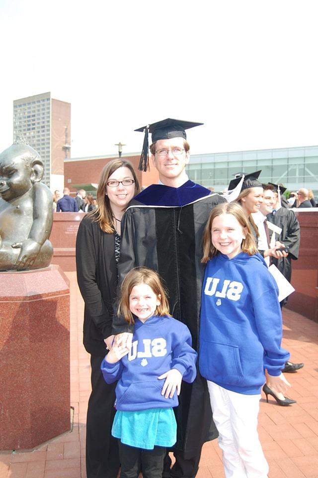 索威尔头戴毕业帽，身穿毕业礼服，与家人在博彩网址大全毕业典礼上合影